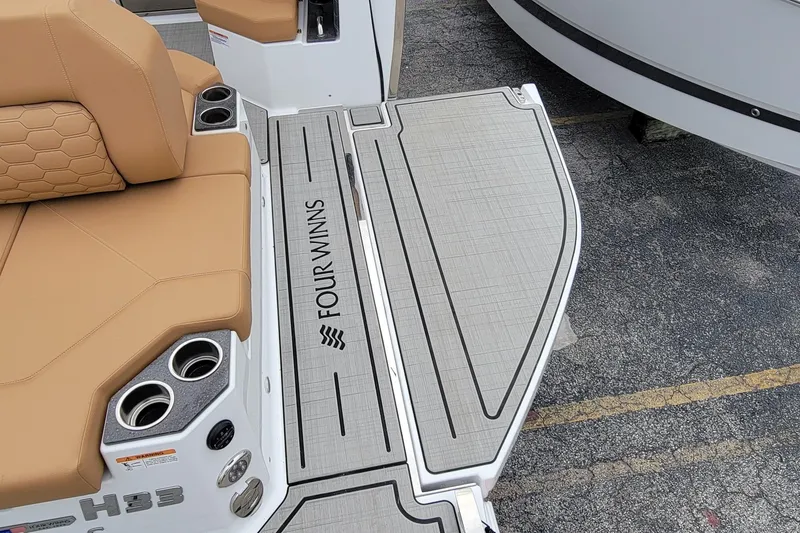 Slide: The Image of 2026 Four Winns H33 OB boat with tan seating and branded deck. - 19