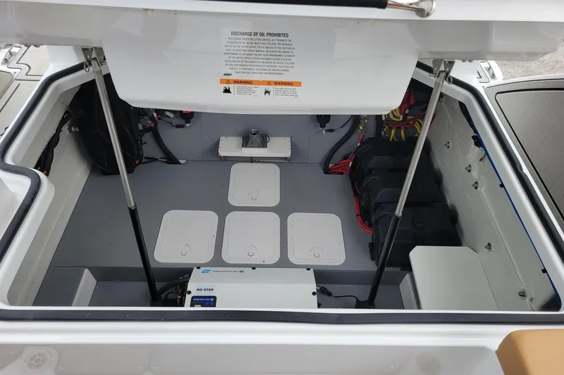 Slide: The Image of 2026 Four Winns H33 OB engine compartment with organized wiring and storage compartments. - 25