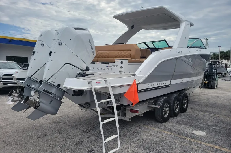 Slide: The Image of 2026 Four Winns H33 OB boat with dual Mercury outboard engines on a trailer. - 3