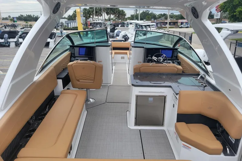 Slide: The Image of 2026 Four Winns H33 OB boat interior with tan seating, modern helm, and sleek design. - 5