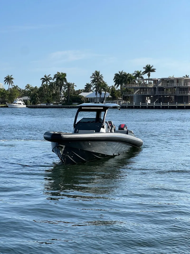 Slide: The Image of 2024 Skipper 38 boat cruising on a sunny day in a tropical waterfront area. - 6