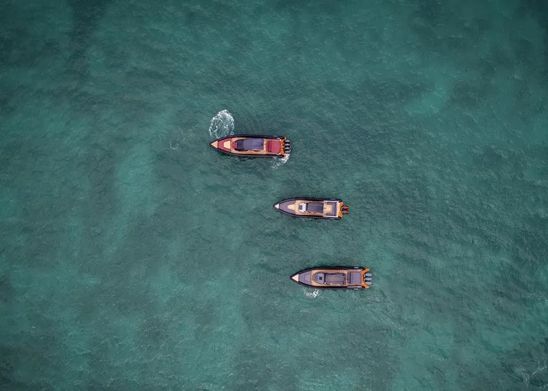 Slide: The Image of Three Skipper 38 boats on clear turquoise water, aerial view, 2024 model. - 12