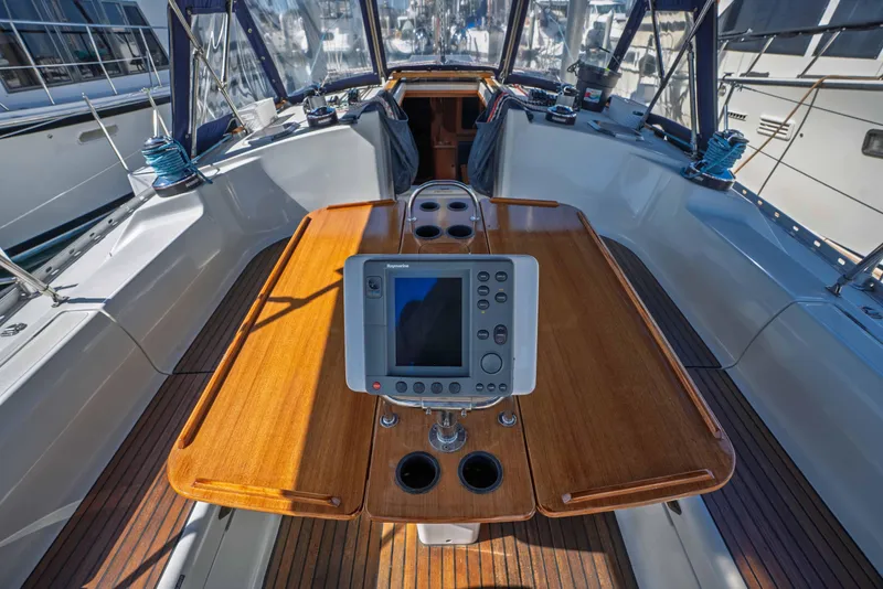 Slide: The Image of Cockpit of 2003 Jeanneau Sun Odyssey 45.2 sailboat with navigation equipment and wooden table. - 22