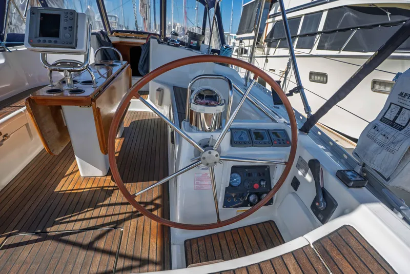 Slide: The Image of Cockpit of 2003 Jeanneau Sun Odyssey 45.2 sailboat with wooden steering wheel and navigation instruments. - 26