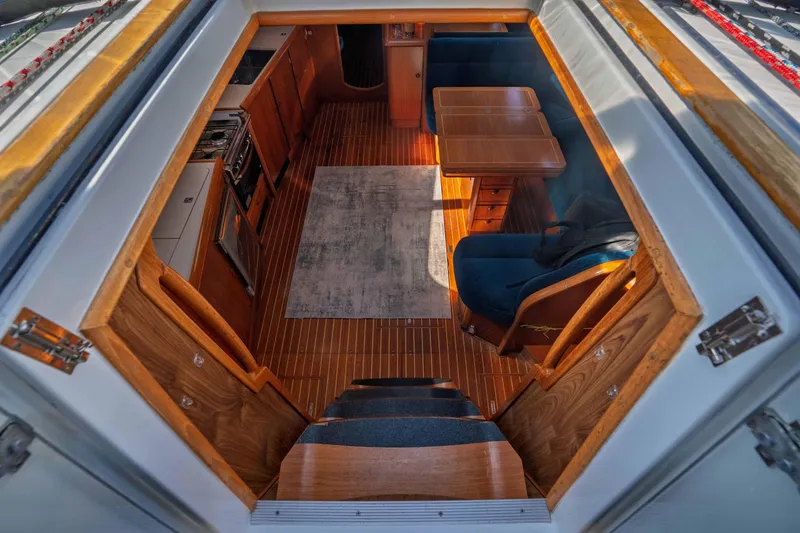 Slide: The Image of Interior view of 2003 Jeanneau Sun Odyssey 45.2 sailboat, featuring wooden cabinetry and seating area. - 36