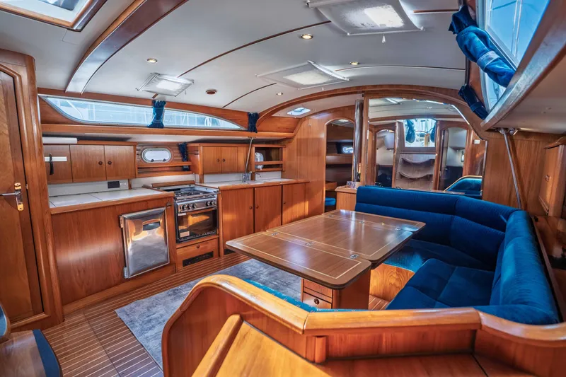 Slide: The Image of Luxurious interior of 2003 Jeanneau Sun Odyssey 45.2 yacht with wood finish and blue seating. - 38