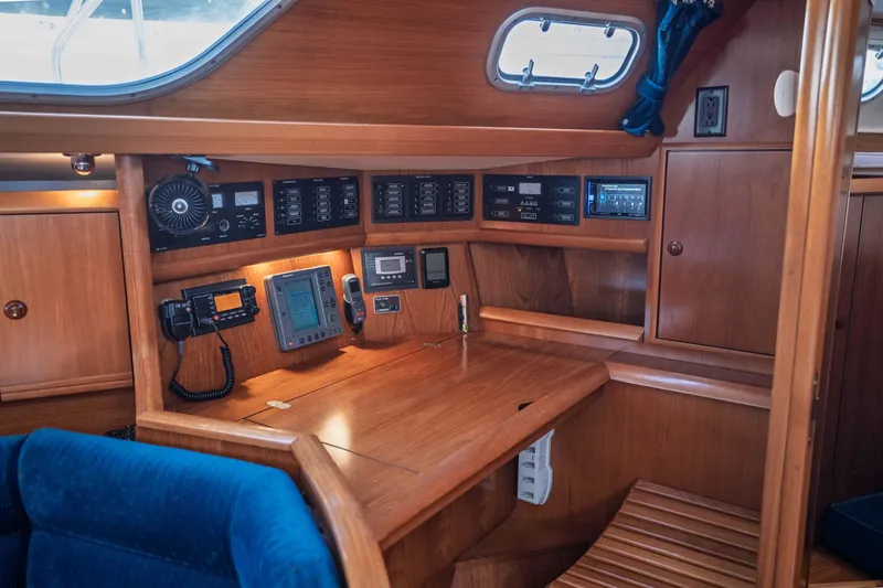 Slide: The Image of Navigation station of 2003 Jeanneau Sun Odyssey 45.2 sailboat with wooden interior and control panels. - 53