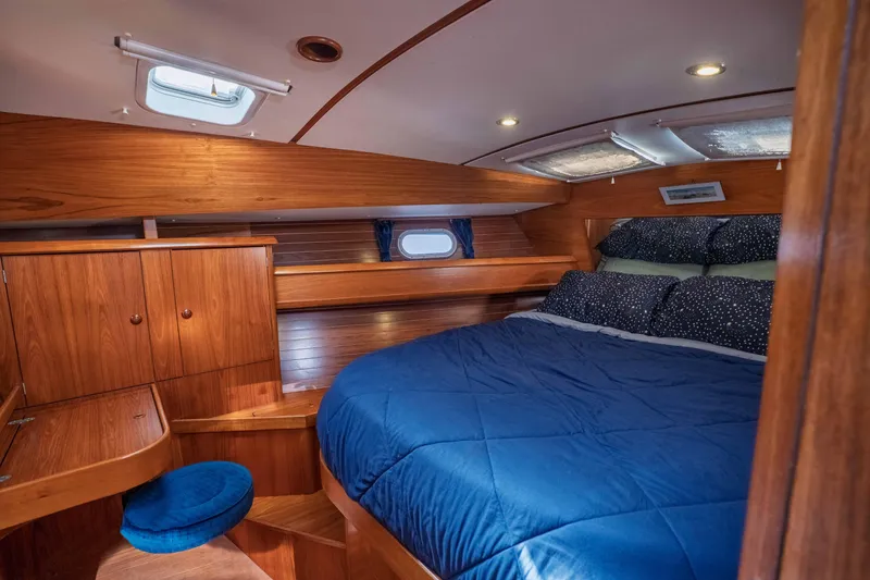 Slide: The Image of Luxurious cabin interior of 2003 Jeanneau Sun Odyssey 45.2 yacht with wood finish and cozy bedding. - 58