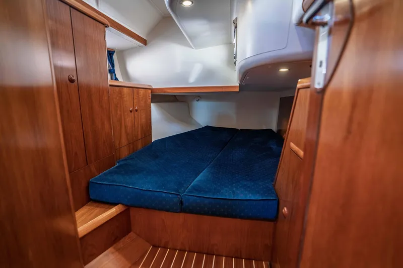 Slide: The Image of Cozy cabin interior of 2003 Jeanneau Sun Odyssey 45.2 with wooden finish and blue bedding. - 68