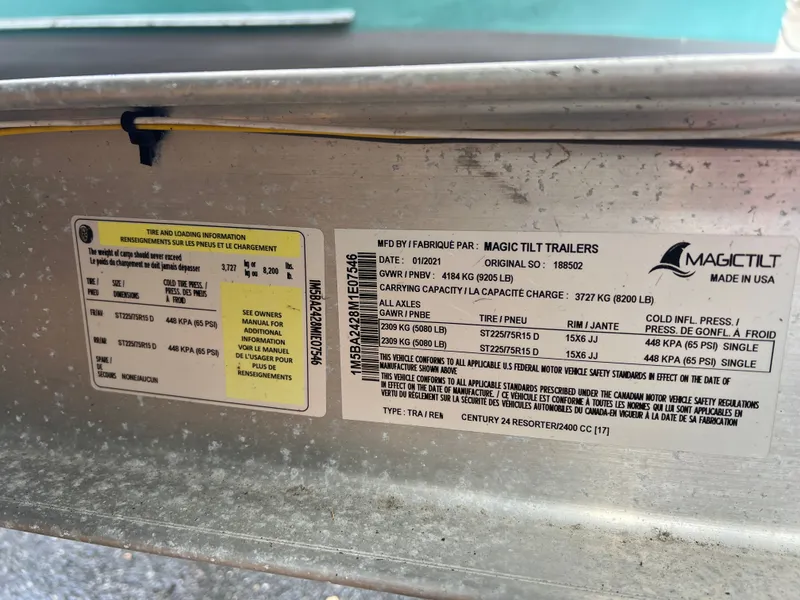 Slide: The Image of Magic Tilt trailer label with tire and loading information. - 13