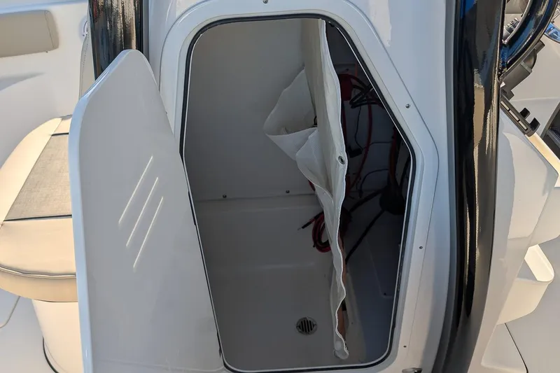 Slide: The Image of Open storage compartment on 2026 Key West 239 FS boat, showing interior space and wiring. - 14