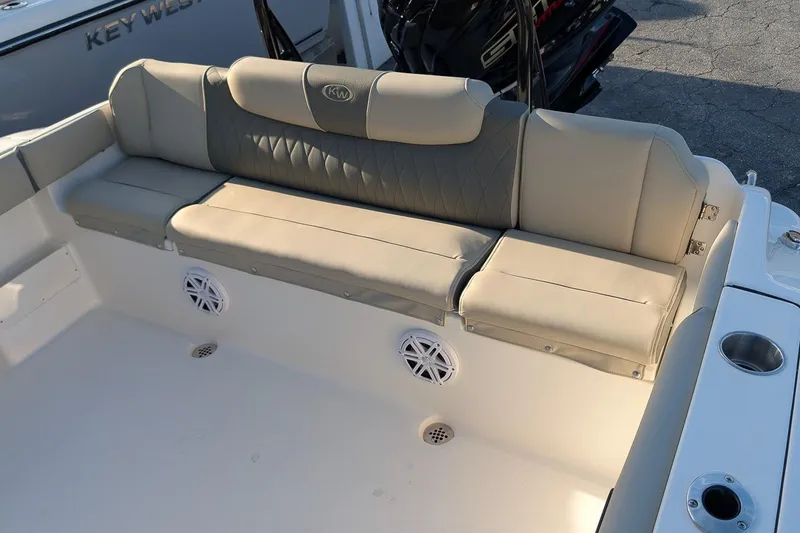 Slide: The Image of 2026 Key West 239 FS boat interior with beige seating and cup holders. - 6