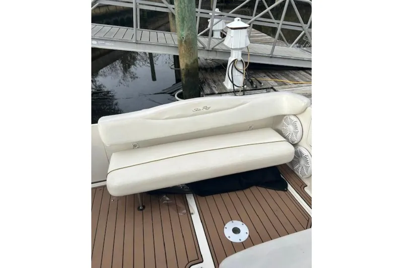 Slide: The Image of 2003 Sea Ray Sundancer 280 boat seating area with white upholstery and wooden deck. - 4