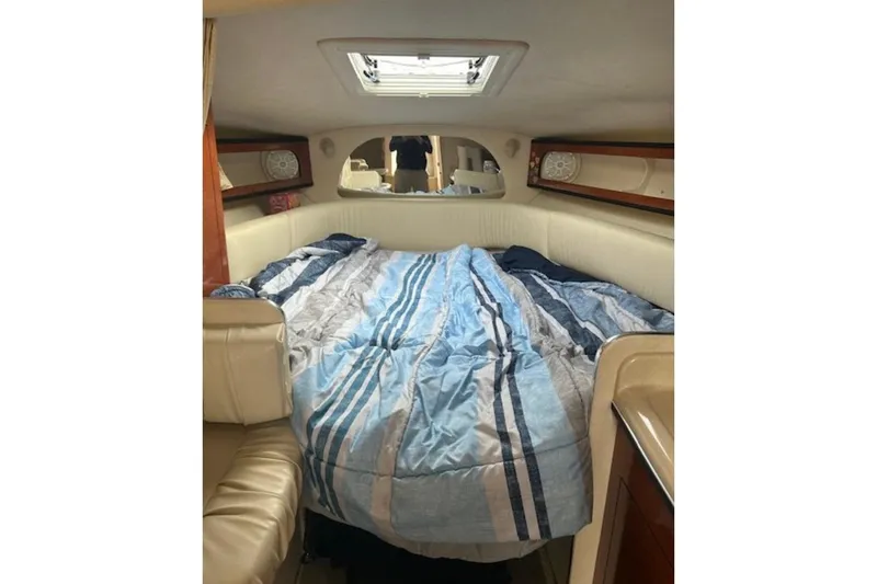 Slide: The Image of Interior cabin of 2003 Sea Ray Sundancer 280 with cozy bed and striped bedding. - 6