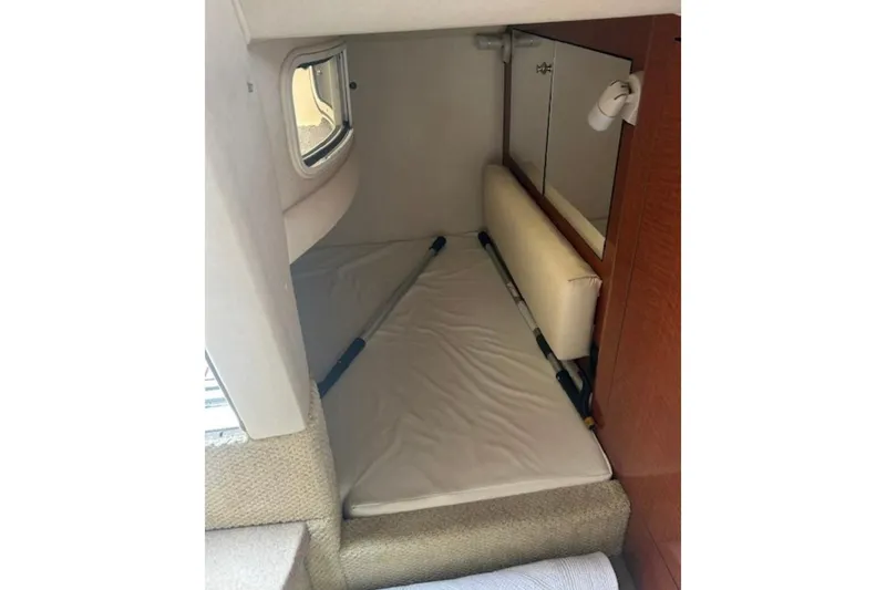Slide: The Image of 2003 Sea Ray Sundancer 280 cabin interior with bed and window view. - 9