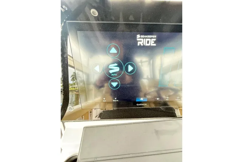 Slide: The Image of 2025 Sportsman Open 352 Center Console boat with tan seating, docked near a modern house. - 9