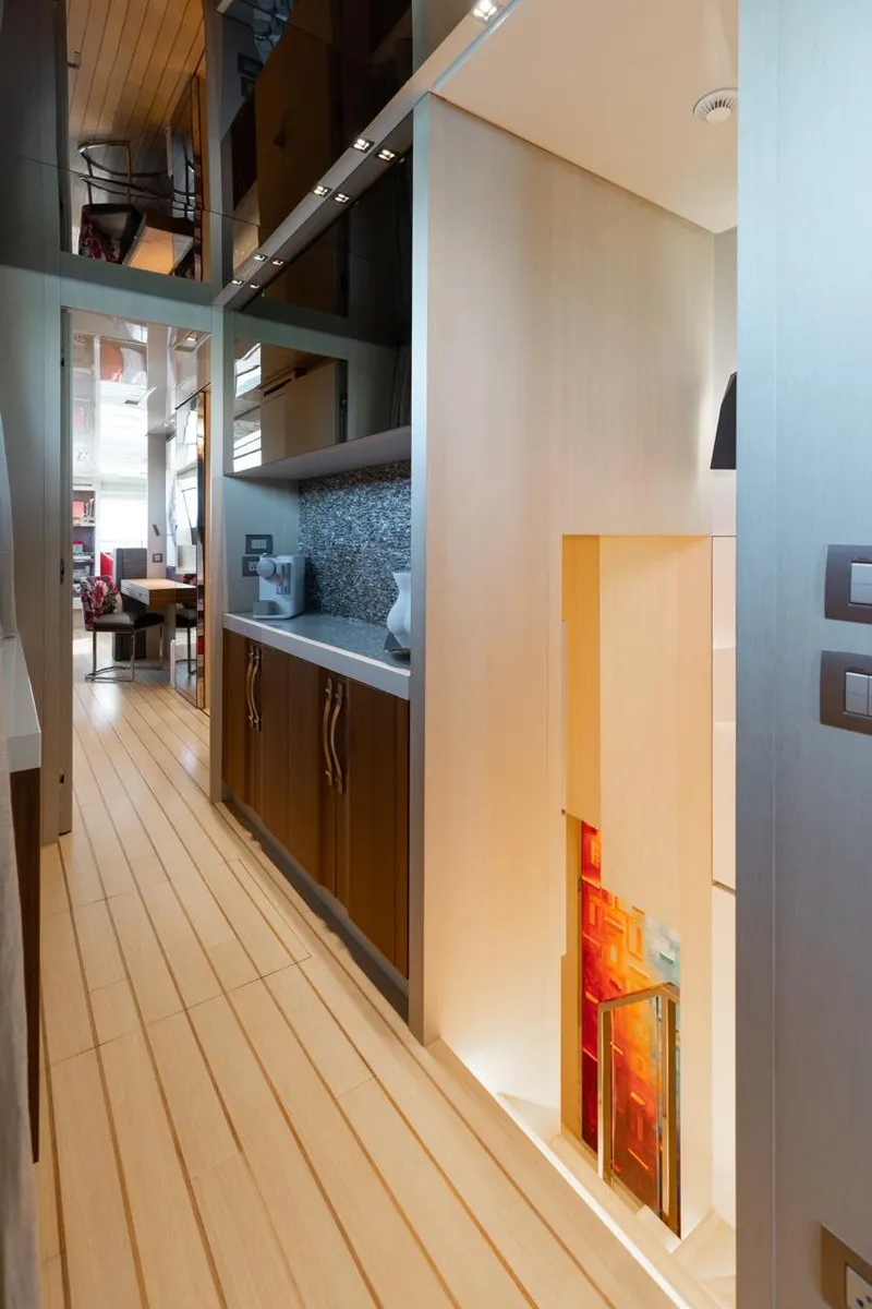 Slide: The Image of Interior of 2018 Sanlorenzo SL106 yacht, featuring sleek wood flooring and modern cabinetry. - 15