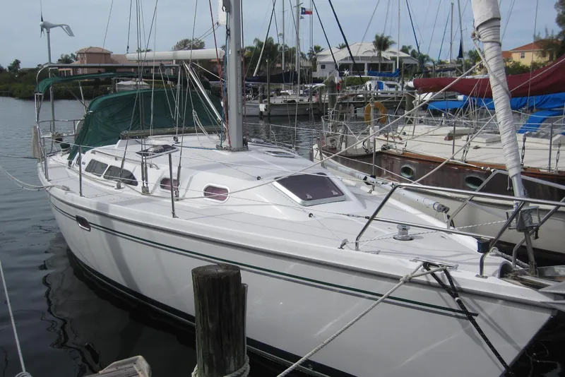 The Image of 2004 Catalina 350 sailboat docked in a marina, surrounded by other boats. - 1