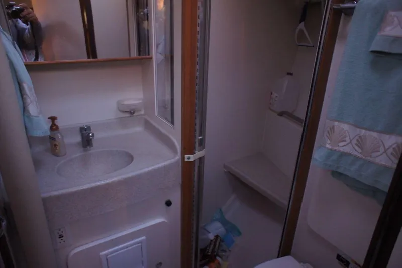 Slide: The Image of Compact bathroom in a 2004 Catalina 350 sailboat, featuring sink and shower area. - 3