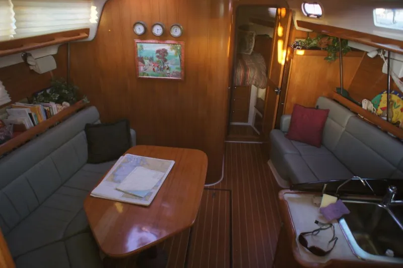 Slide: The Image of Interior of 2004 Catalina 350 sailboat with cozy seating and wooden finishes. - 6