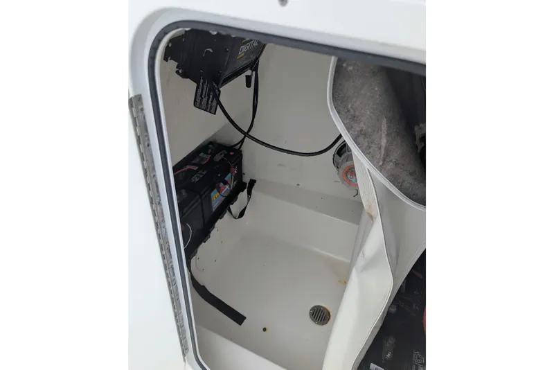 Slide: The Image of 2017 Tidewater 210 LXF boat storage compartment with battery and wiring. - 5