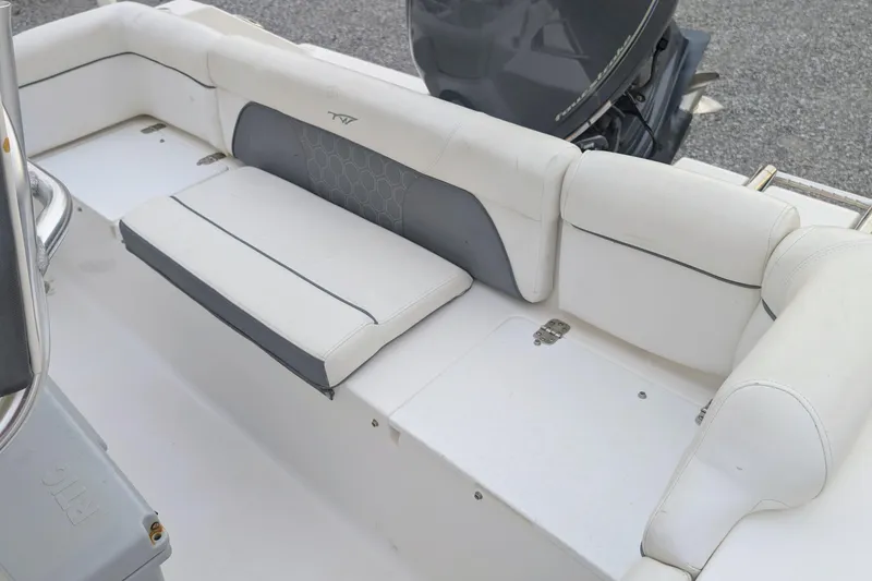 Slide: The Image of 2017 Tidewater 210 LXF boat interior with white cushioned seating and motor. - 9