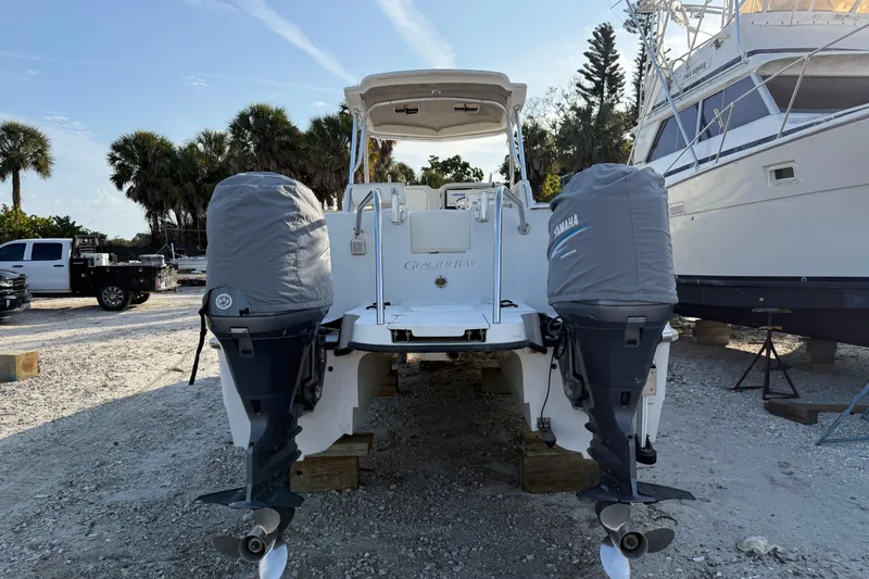 Slide: The Image of 2005 Glacier Bay 2680 Coastal Runner with twin Yamaha outboard motors in a boatyard setting. - 4