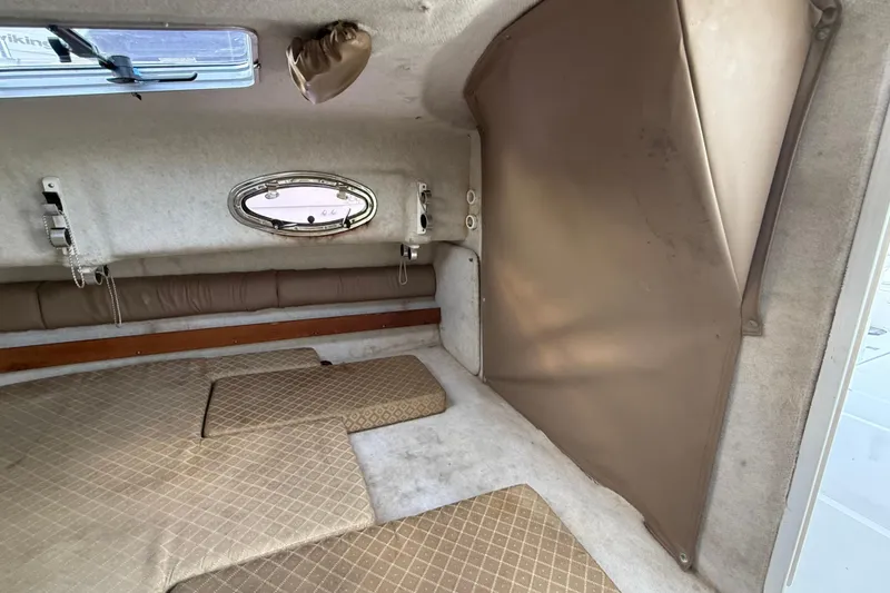 Slide: The Image of Interior cabin of 2005 Glacier Bay 2680 Coastal Runner boat, featuring cushions and porthole. - 44