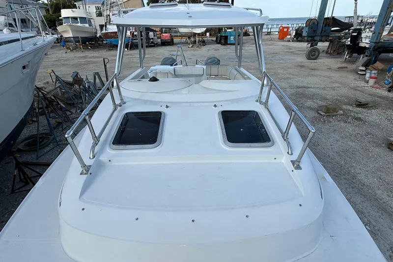 Slide: The Image of 2005 Glacier Bay 2680 Coastal Runner boat on dry dock, featuring spacious deck and dual hatches. - 48