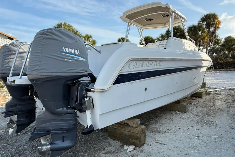 Slide: The Image of 2005 Glacier Bay 2680 Coastal Runner boat with Yamaha engines on a sandy shore. - 5