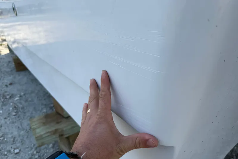 Slide: The Image of Hand inspecting 2005 Glacier Bay 2680 Coastal Runner boat hull surface. - 54