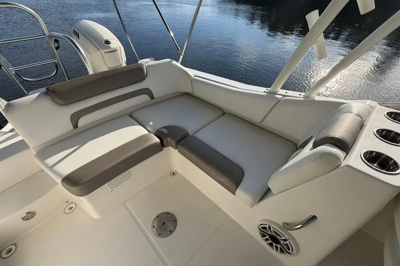 Slide: The Image of 2020 World Cat 230 SD boat interior with cushioned seating and cup holders by the water. - 11
