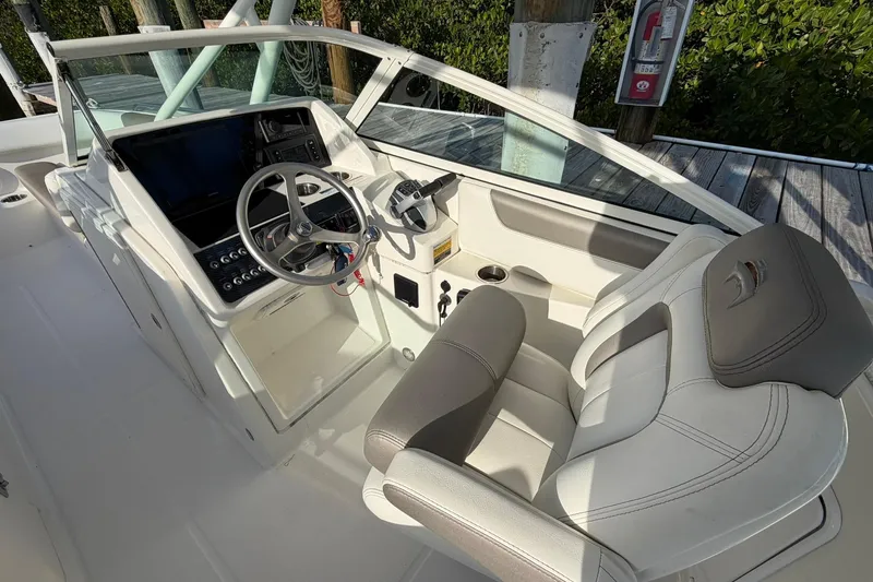 Slide: The Image of 2020 World Cat 230 SD boat interior with steering wheel and seating. - 13