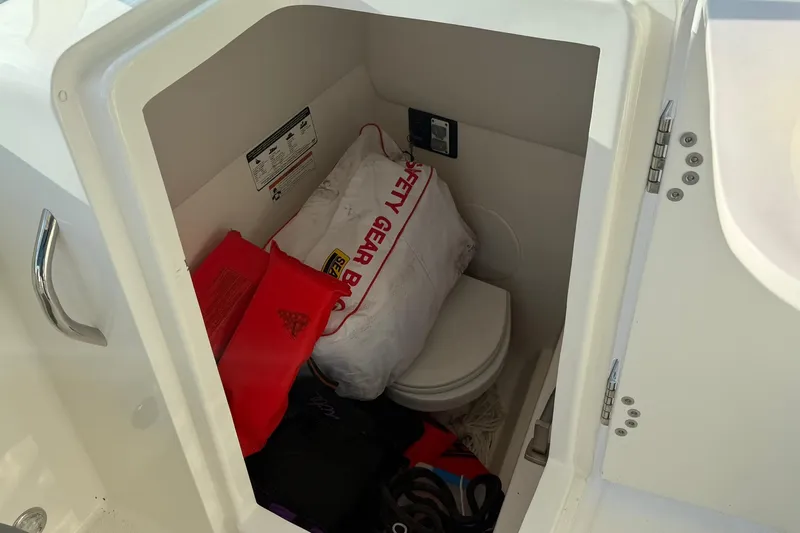 Slide: The Image of Storage compartment in a 2020 World Cat 230 SD boat with safety gear and equipment. - 14