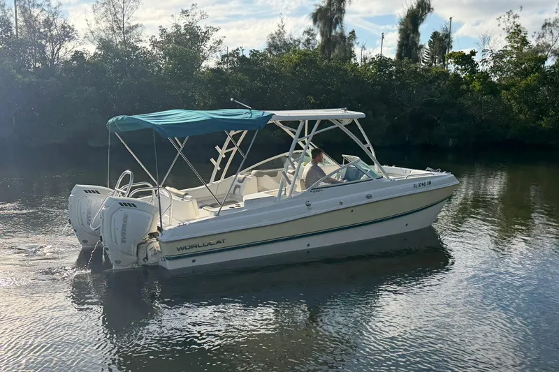 Slide: The Image of 2020 World Cat 230 SD boat cruising on a calm river with lush greenery. - 2