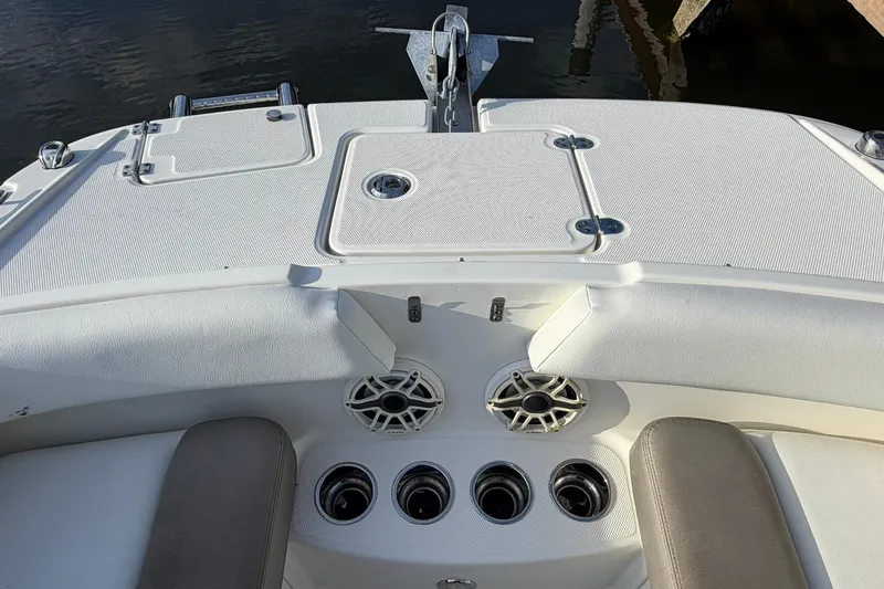Slide: The Image of 2020 World Cat 230 SD boat interior with speakers and seating, docked by water. - 20