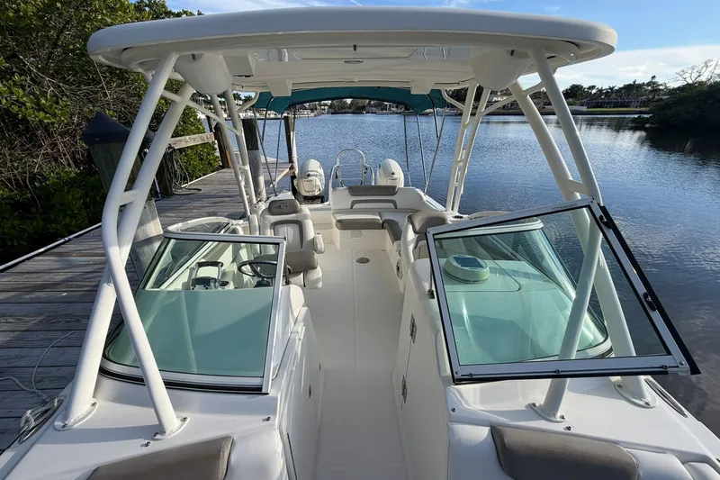 Slide: The Image of 2020 World Cat 230 SD boat docked on a serene lake with open seating. - 21