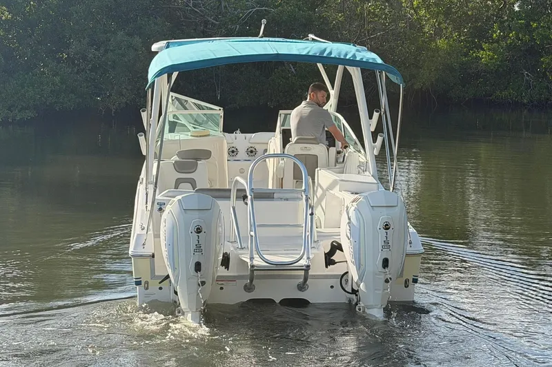 Slide: The Image of 2020 World Cat 230 SD boat with dual engines on a calm waterway. - 26