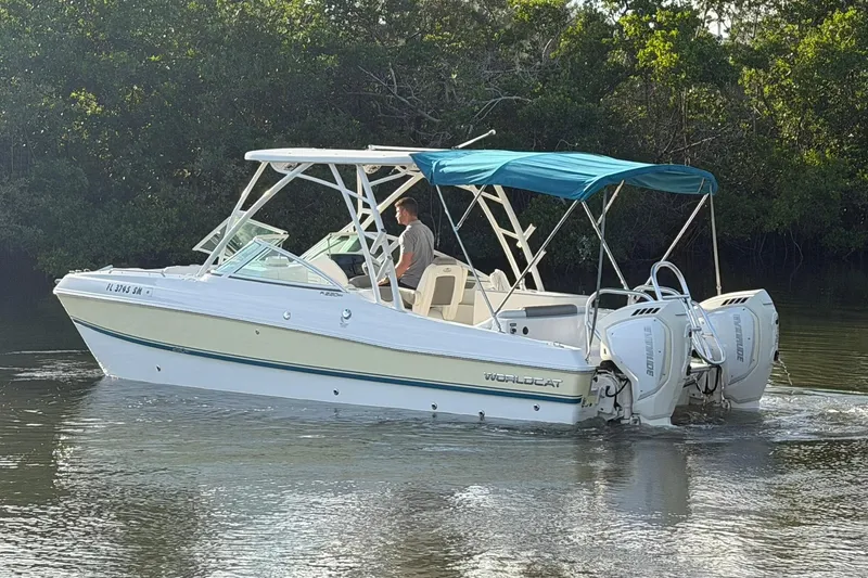 Slide: The Image of 2020 World Cat 230 SD boat with blue canopy cruising on calm water. - 28