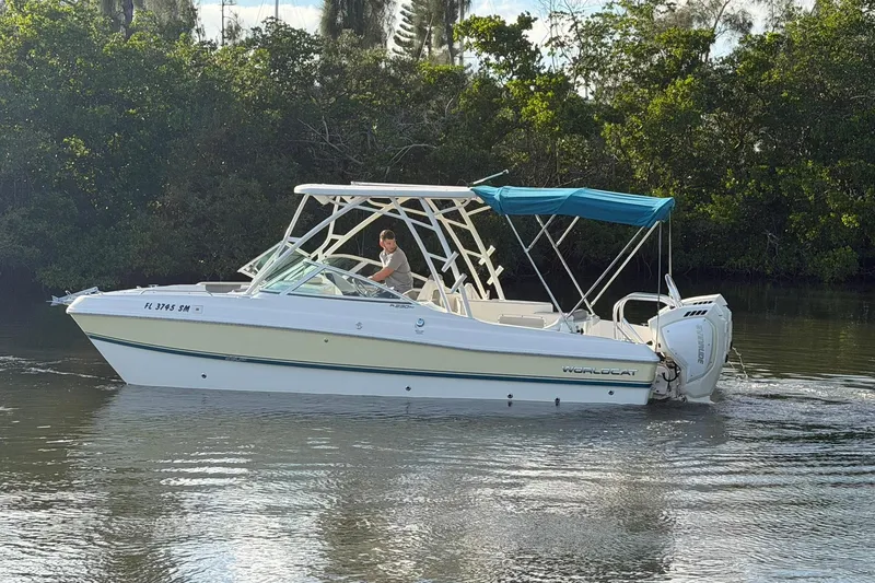 Slide: The Image of 2020 World Cat 230 SD boat cruising on a calm river with lush greenery. - 29