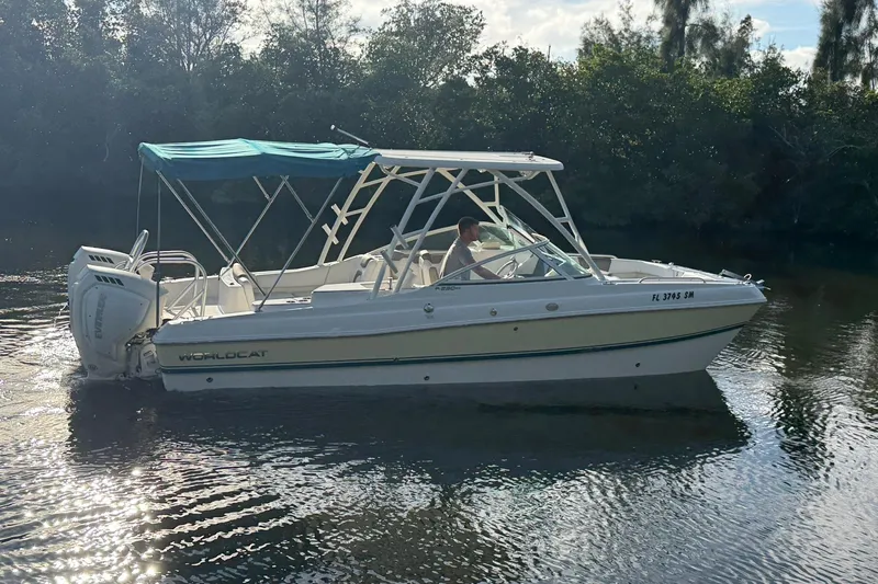 Slide: The Image of 2020 World Cat 230 SD boat cruising on a calm river with canopy. - 4