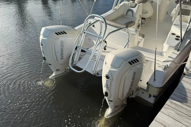 Slide: The Image of 2020 World Cat 230 SD boat with dual Evinrude engines docked on water. - 6