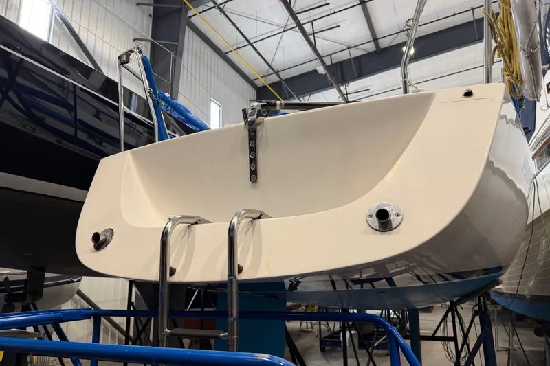 Slide: The Image of 2006 J Boats J/100 sailboat in storage, rear view with ladder and fittings. - 17