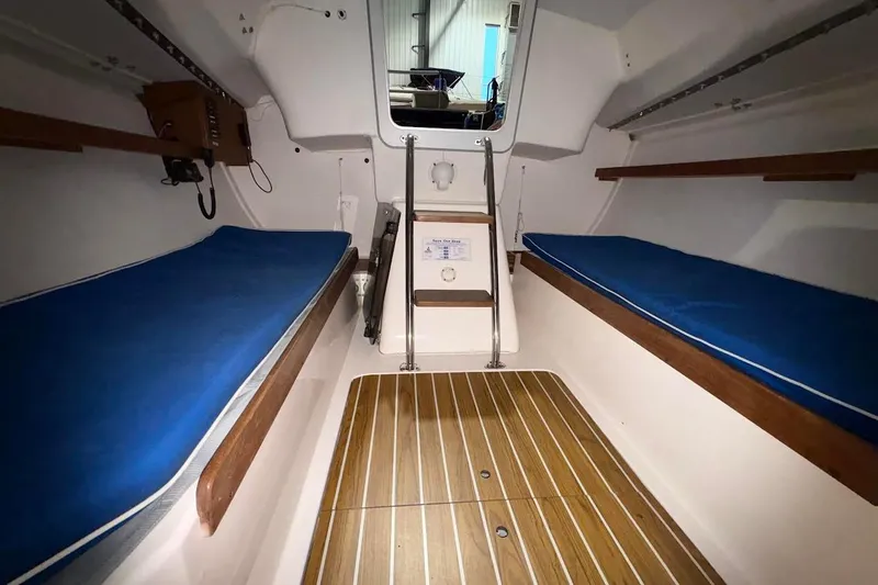 Slide: The Image of Interior of 2006 J Boats J/100 sailboat with blue cushions and wooden flooring. - 28