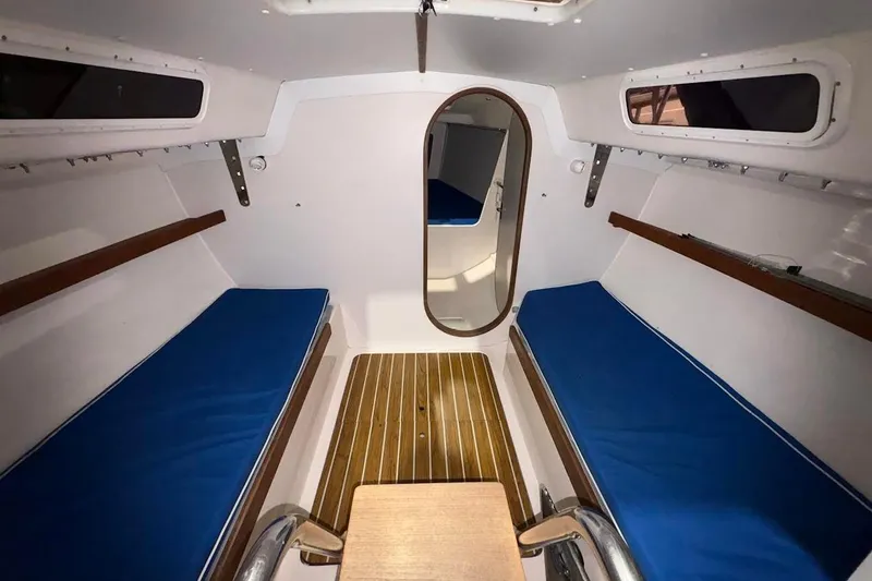 Slide: The Image of 2006 J Boats J/100 cabin interior with blue cushions and wooden flooring. - 29