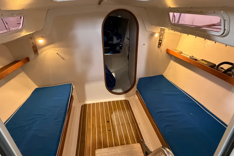Slide: The Image of 2006 J Boats J/100 cabin interior with blue cushions and wooden flooring. - 35