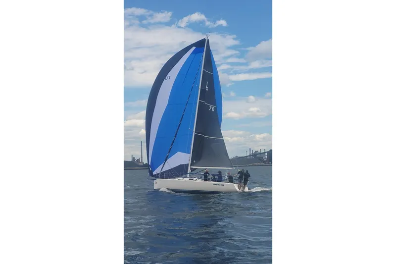 Slide: The Image of 2006 J Boats J/100 sailing with blue and black spinnaker on open water. - 4