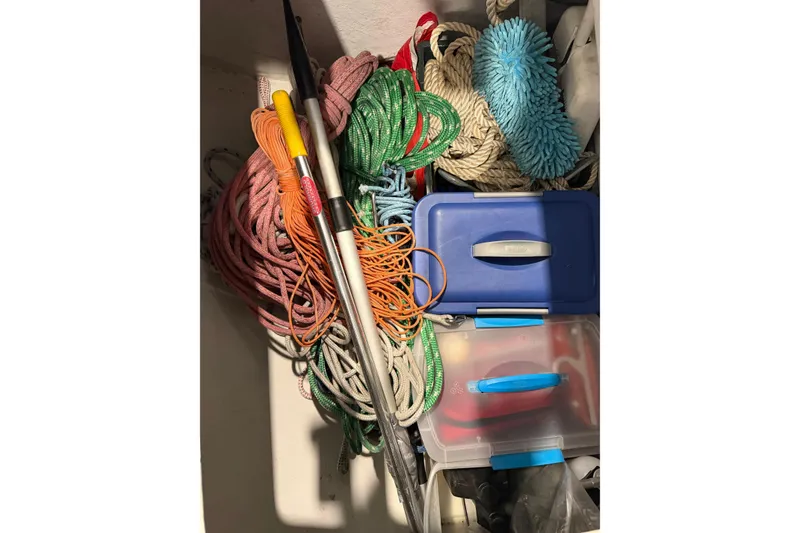 Slide: The Image of Storage compartment with colorful ropes, cleaning supplies, and containers on a 2006 J Boats J/100. - 55