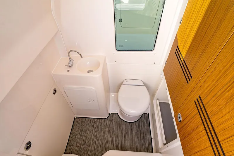 Slide: The Image of Manufacturer Provided Image: Compact bathroom in 2026 Solace 30 CS boat with sink, toilet, and wooden cabinet. - 15