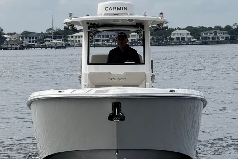 Slide: The Image of 2026 Solace 30 CS boat on water, front view with Garmin equipment. - 2